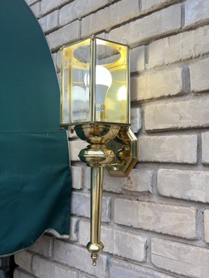 Plugged Electricians ATL — polished brass carriage-style outdoor wall light installed on brick exterior