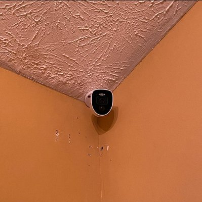 Plugged Electricians ATL — exterior-grade security camera mounted in the corner of a covered porch